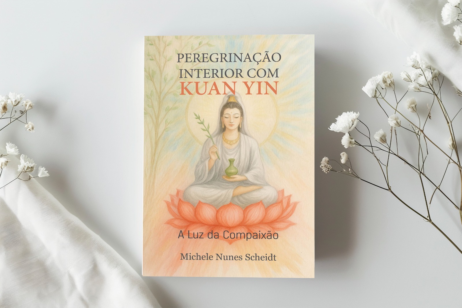 Livro Peregrinação Interior com Kuan Yin — A Luz da Compaixão, de Michele Nunes Scheidt, entre flores brancas