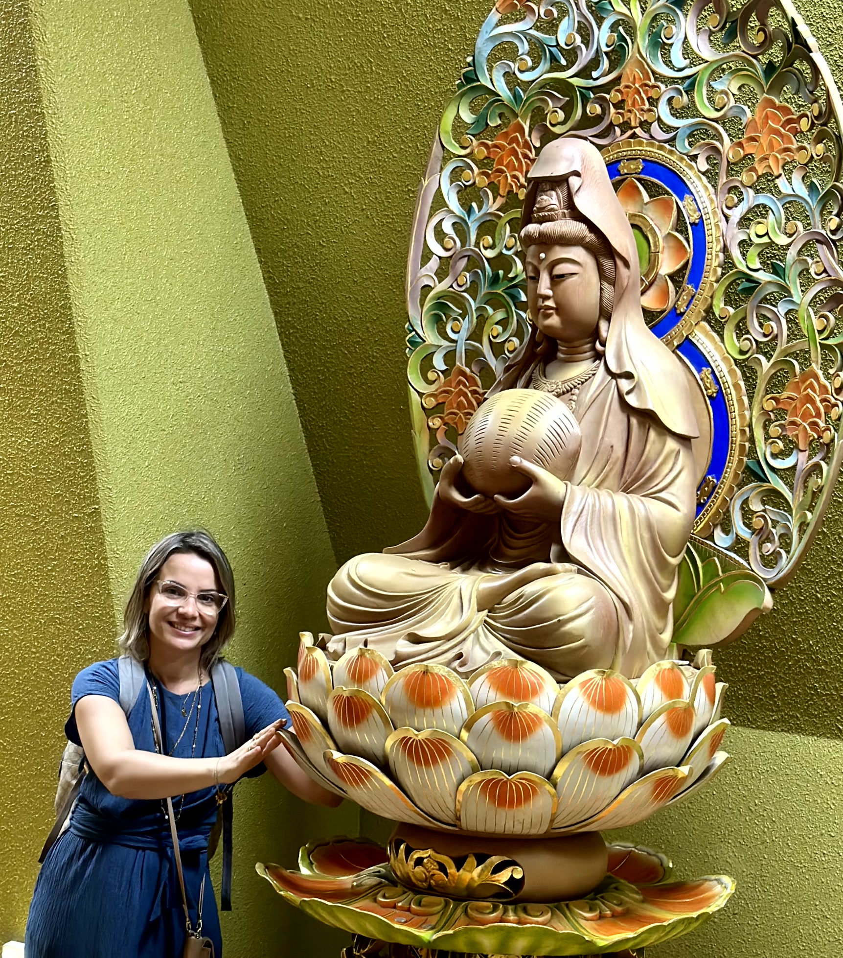Michele ao lado de uma escultura de Kuan Yin sobre flor de lótus no Sendai Daikannon